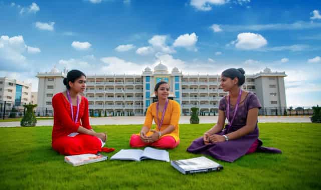 Akash Institute of Medical Sciences main building with students on the campus lawn, Devanahalli, Bengaluru