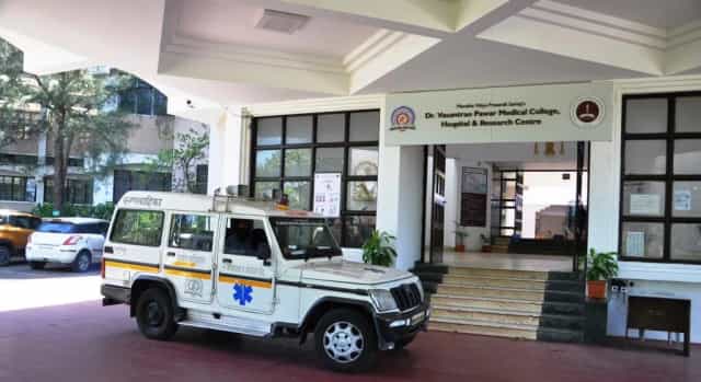 Main entrance of Dr. Vasantrao Pawar Medical College, Hospital & Research Centre, Nashik with the college name board and an ambulance at the porch