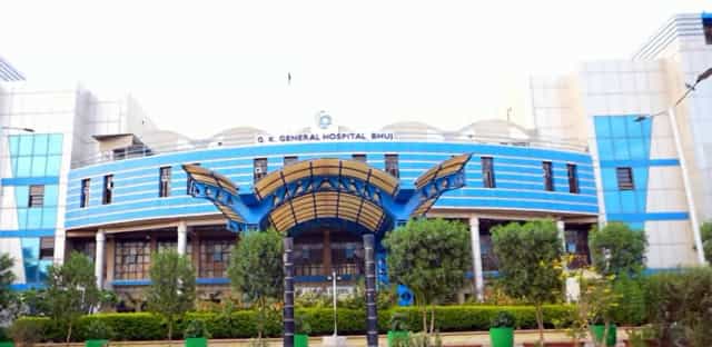 Front facade of G. K. General Hospital, the teaching hospital of Gujarat Adani Institute of Medical Sciences (GAIMS), Bhuj, with rooftop signage reading G. K. GENERAL HOSPITAL BHUJ