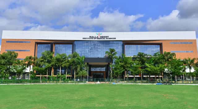 Front elevation of Malla Reddy Institute of Medical Sciences, Suraram, Hyderabad, with the college name on the facade and lawns in front