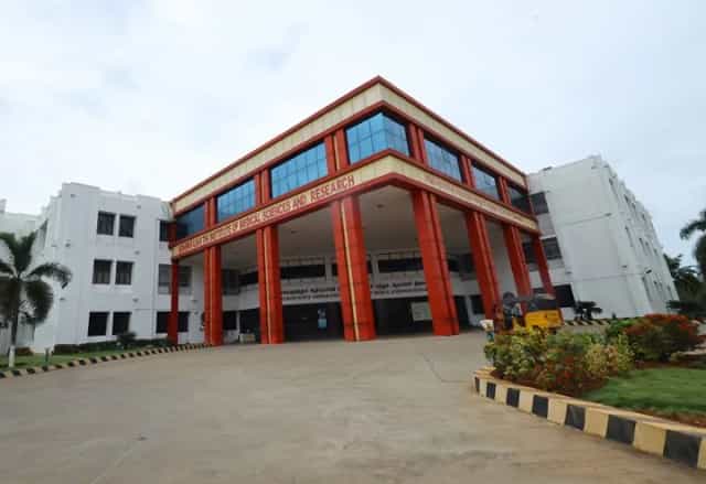 Front facade of the Melmaruvathur Adhiparasakthi Institute of Medical Sciences and Research main building with its red-columned portico