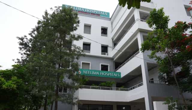 Exterior of the Neelima Hospitals teaching hospital at Ghatkesar, Hyderabad, with rooftop signage reading NEELIMA HOSPITALS
