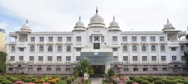 Main building of Sri Devaraj Urs Medical College at Tamaka, Kolar, with its domed white facade and landscaped front garden