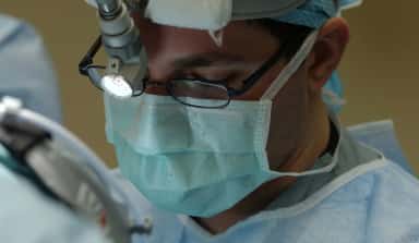 Surgeon operating with a microscope in an operation theatre at Adichunchanagiri Hospital
