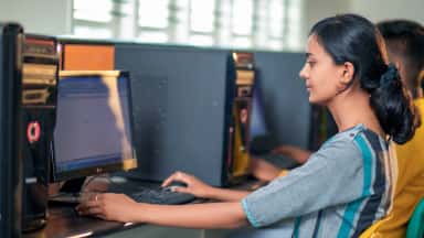 Student at a workstation in the digital library of Akash Institute of Medical Sciences, Devanahalli