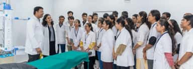 Faculty member demonstrating to MBBS students around a teaching table at Ananya College of Medicine & Research, Kalol