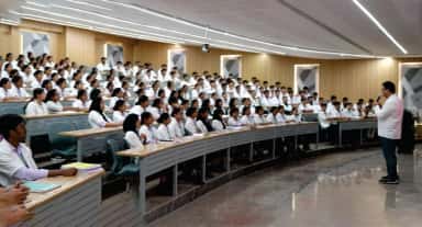 MBBS students in white coats filling the tiered lecture theatre at BGS Medical College and Hospital