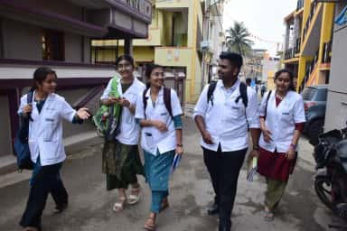 BGS Medical College and Hospital MBBS students in white coats during a Family Adoption Programme village visit