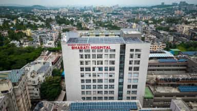 Aerial view of the Bharati Hospital tower at Dhankawadi, Pune with rooftop signage