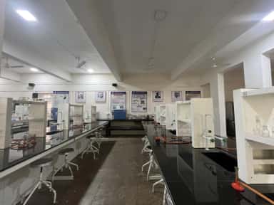 Biochemistry laboratory with benches and college display posters at BAVMC Pune