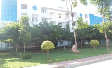 Academic block with landscaped lawns on the Chettinad Health City campus at Kelambakkam