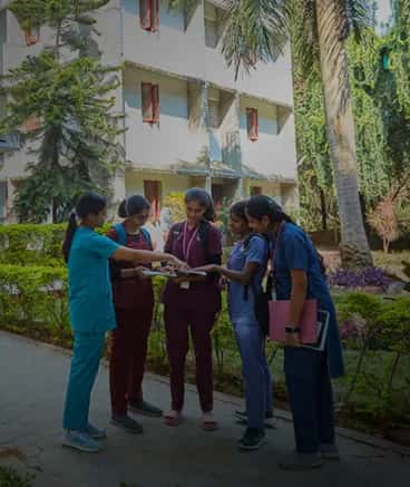 Christian Medical College Vellore students in clinical attire discussing on the college campus