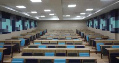 Tiered lecture theatre with stepped wooden desks and blue seating at Datta Meghe Medical College, Nagpur