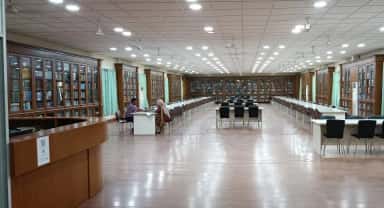 Central library reading hall at Deccan College of Medical Sciences with wooden book cabinets and study tables