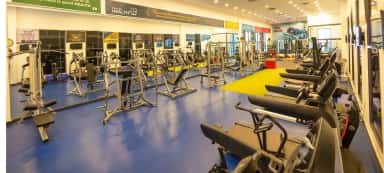 Gymnasium at Deccan College of Medical Sciences with exercise machines and health-quote banners