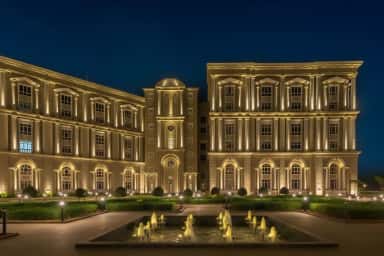 Floodlit CDSIMER academic buildings and fountain courtyard at night, Harohalli