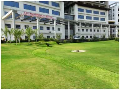 Smt. S.M.S. Multispeciality Hospital building with campus lawn at Dr. M.K. Shah Medical College, Chandkheda, Ahmedabad