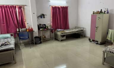 Shared hostel room with beds and study tables at Dr. Patnam Mahender Reddy Institute of Medical Sciences