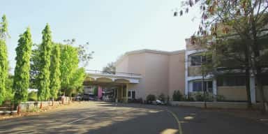 Tree-lined approach road and porch of the Dr. Vasantrao Pawar Medical College campus at Adgaon
