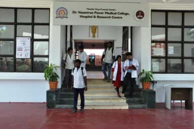 MBBS students on the steps of the Dr. Vasantrao Pawar Medical College main entrance under the college name board
