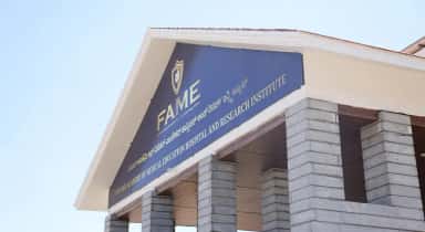 FAME building gable with the institute's name signage against the sky, Mysore