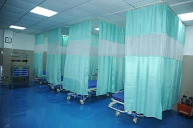 Inpatient ward with hospital beds and privacy curtains at Indira Medical College & Hospitals, Pandur