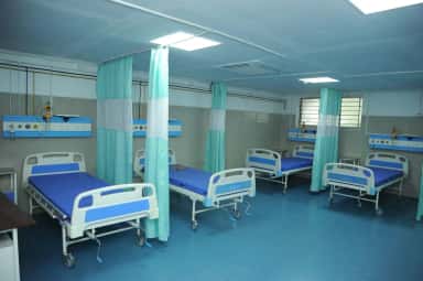 Hospital ward with rows of beds and bedside curtains at the Indira teaching hospital, Thiruvallur