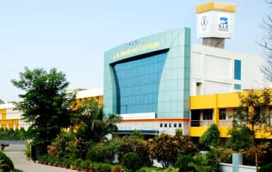 Main building of KLE Jawaharlal Nehru Medical College in Belagavi with the college name on its glass facade and the KLE tower behind