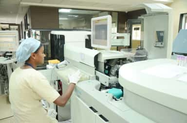 Lab technician operating an automated analyser in the hi-tech laboratory at Jawaharlal Nehru Medical College Belagavi