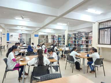 MBBS students in white coats at the library reading hall of KLE JGMM Medical College, Hubballi