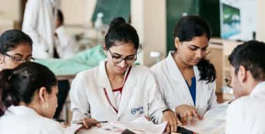 Students in NITTE-KSHEMA aprons studying together in a practical hall at K S Hegde Medical Academy