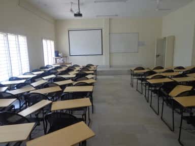 Tiered lecture classroom with projector and writing-pad chairs at Kamineni Academy of Medical Sciences, Hyderabad
