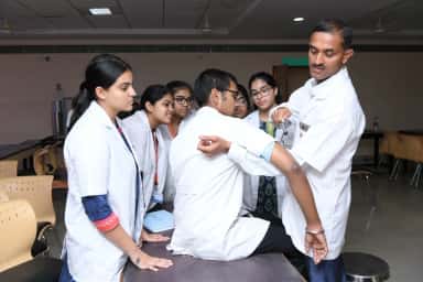 KMC Manipal faculty member demonstrating a clinical examination technique to a group of students