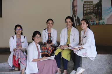 MBBS students of KVG Medical College Sullia in white coats on the campus steps