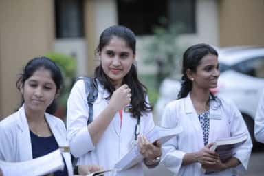 KVG Medical College students with textbooks and stethoscopes outside the academic block