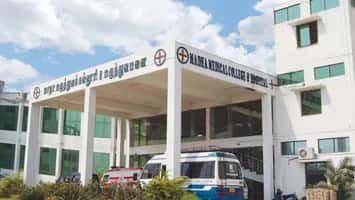 Entrance porch of Madha Medical College and Hospital, Chennai, signed 'Madha Medical College & Hospital', with ambulances parked outside