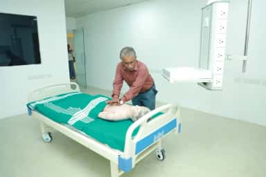 Faculty demonstrating CPR on a training mannequin in the clinical skills lab at Meenakshi Medical College, Kanchipuram