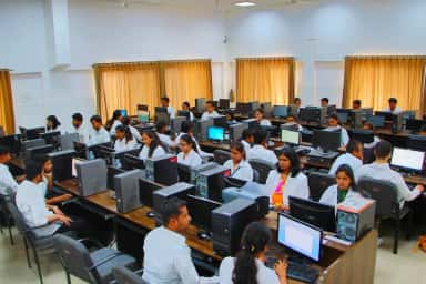 Students in white coats working at desktop computers in the e-learning centre of MGM Medical College, Aurangabad