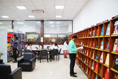 Central medical library of MGM Medical College, Aurangabad, with wooden stacks of textbooks and students reading at tables