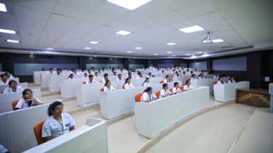 Tiered examination and computer hall at Navodaya Medical College with students at desks