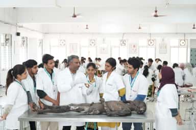 Faculty member teaching MBBS students around a dissection table in the anatomy hall at Neelima Institute of Medical Sciences