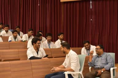 Students and faculty in a tiered lecture and seminar hall at Neelima Institute of Medical Sciences