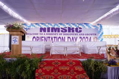 Orientation Day 2024 stage with NIMSRC welcome banner at Nova Institute of Medical Sciences