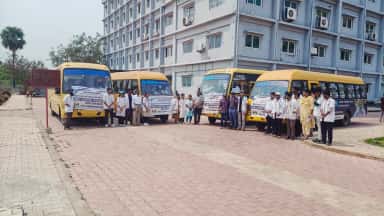 Nova college buses lined up with students outside the campus block before a community medicine outreach visit
