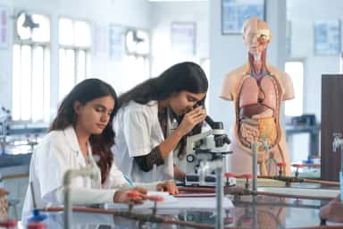 MBBS students examining slides under microscopes in the pathology laboratory at Parul Institute of Medical Sciences & Research, Vadodara
