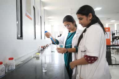 Students pipetting reagents at the bench in the biochemistry practical lab, PESU IMSR Bengaluru