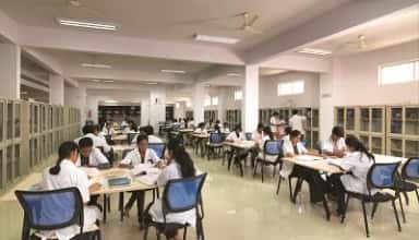 Students in white coats studying in the library reading room at Sapthagiri Institute of Medical Sciences, Bengaluru