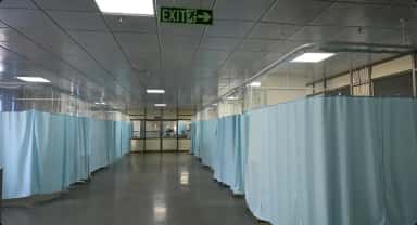 Curtained inpatient beds in a ward at the General Hospital, Shantabaa Medical College, Amreli