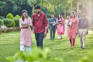 MBBS students with stethoscopes walking on the green campus lawns at Shridevi Institute of Medical Sciences Tumkur