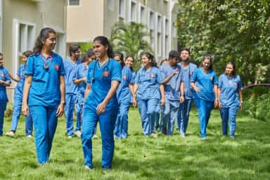 Group of medical students in blue clinical scrubs on the campus lawns at Shridevi Institute of Medical Sciences Tumkur